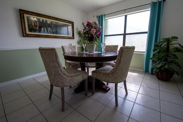 dining room featuring baseboards and light tile patterned floors