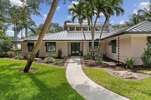 121 Hillcrest Dr, Sewalls Point, FL 34996 - mid-century inspired home with a standing seam roof, stucco siding, metal roof, french doors, and a front yard