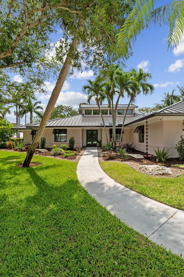 121 Hillcrest Dr, Sewalls Point, FL 34996 - mid-century home featuring a standing seam roof, stucco siding, french doors, and metal roof