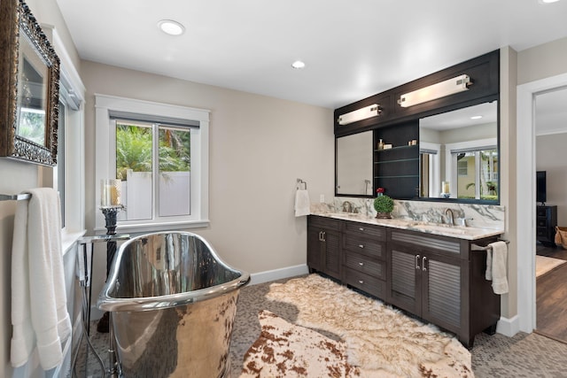 121 Hillcrest Dr, Sewalls Point, FL 34996 - bathroom with double vanity, a freestanding bath, recessed lighting, and baseboards