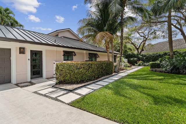 121 Hillcrest Dr, Sewalls Point, FL 34996 - view of side of property with a standing seam roof, stucco siding, a lawn, and metal roof