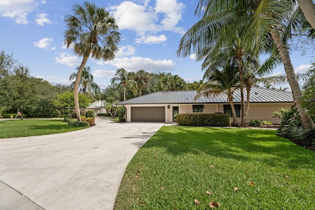 121 Hillcrest Dr, Sewalls Point, FL 34996 - ranch-style home with metal roof, an attached garage, driveway, and a front lawn
