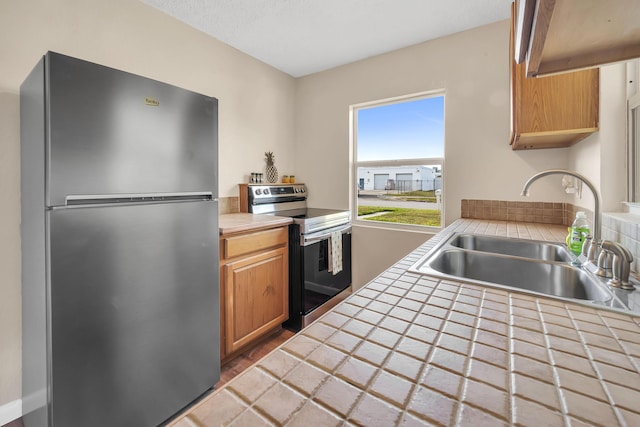 3205 Tennessee Ave, Fort Pierce, FL 34950 - kitchen featuring tile counters, appliances with stainless steel finishes, and a sink