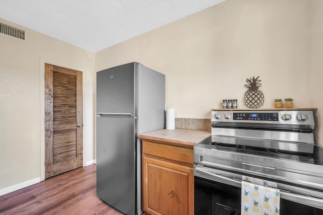 3205 Tennessee Ave, Fort Pierce, FL 34950 - kitchen featuring appliances with stainless steel finishes, baseboards, wood finished floors, and visible vents
