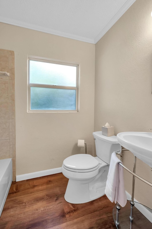 3205 Tennessee Ave, Fort Pierce, FL 34950 - full bathroom with ornamental molding, wood finished floors, toilet, baseboards, and a tub