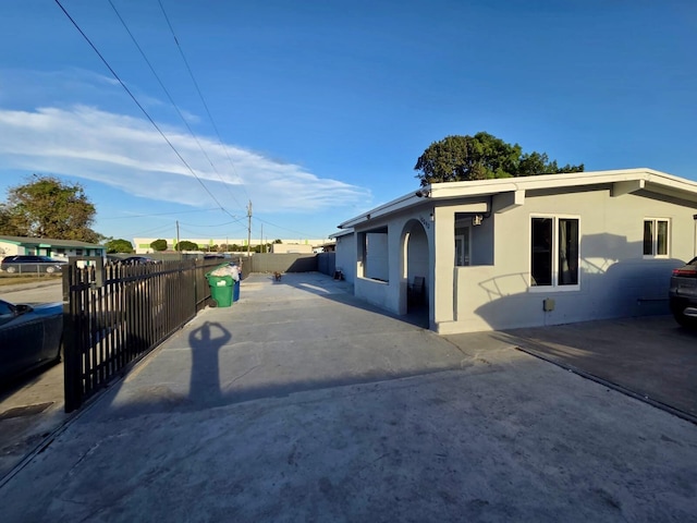 10090 W Fern St, Miami, FL 33157 - view of side of property featuring fence, stucco siding, and a patio area