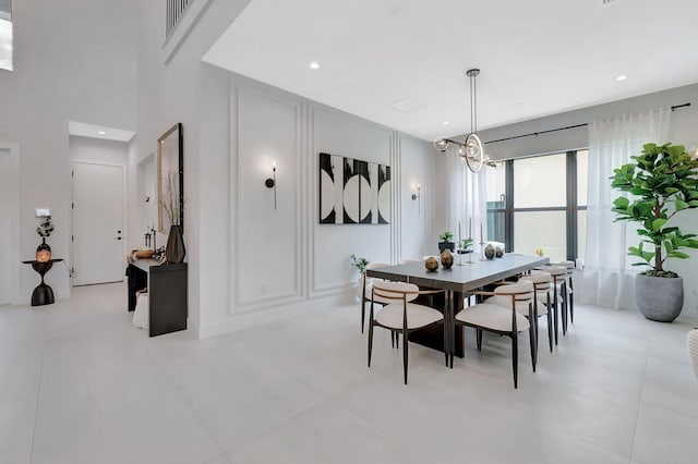 dining area with recessed lighting, a decorative wall, and a chandelier