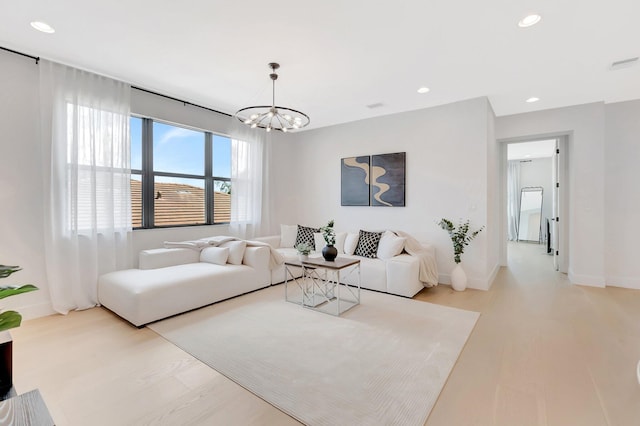 living area featuring recessed lighting, a notable chandelier, and wood finished floors