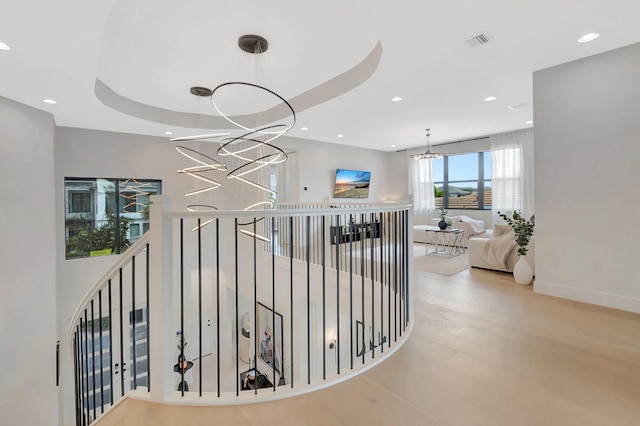 hall with visible vents, recessed lighting, a notable chandelier, and an upstairs landing