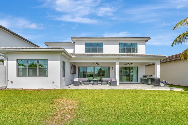 rear view of property with stucco siding, an outdoor living space, a patio area, a lawn, and a ceiling fan
