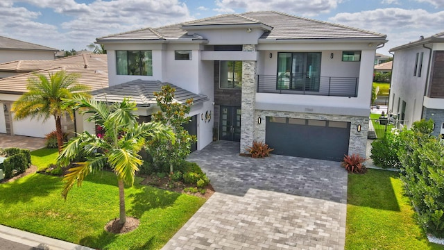 view of front of house with stucco siding, decorative driveway, a front yard, and a garage