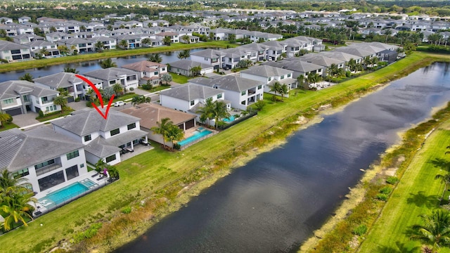 drone / aerial view featuring a residential view and a water view