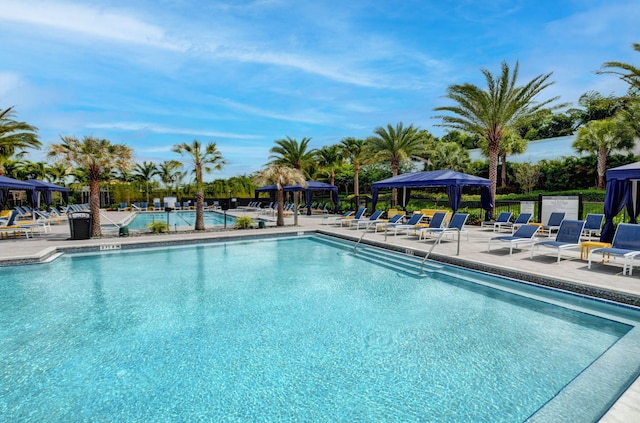 pool with a gazebo, fence, and a patio