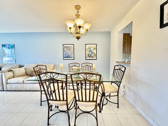 dining area with a textured ceiling, light tile patterned flooring, and a notable chandelier