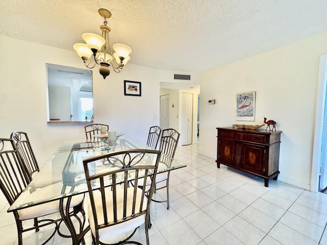 dining area featuring light tile patterned floors, a textured ceiling, a chandelier, and visible vents