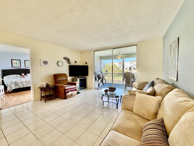 living room featuring a textured ceiling, floor to ceiling windows, and light tile patterned floors