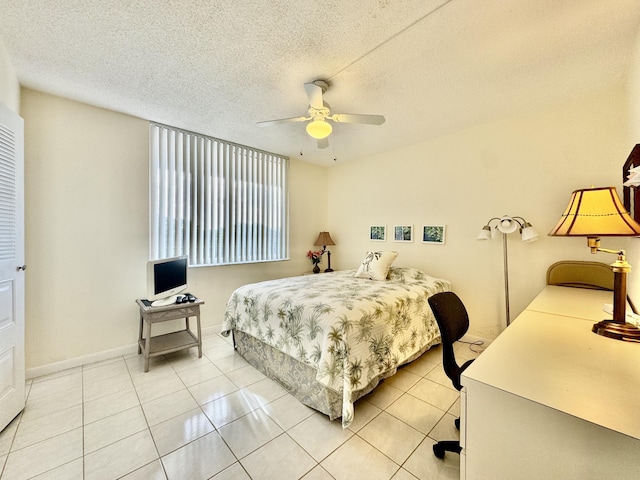 bedroom featuring a textured ceiling, ceiling fan, and light tile patterned flooring