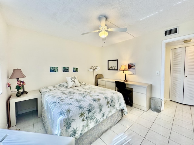bedroom with a ceiling fan, visible vents, and light tile patterned floors