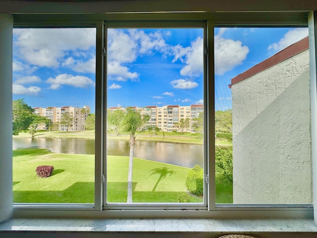 doorway featuring plenty of natural light, a textured wall, and a water view