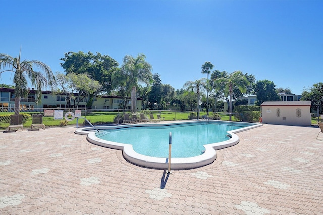 community pool with a patio and fence