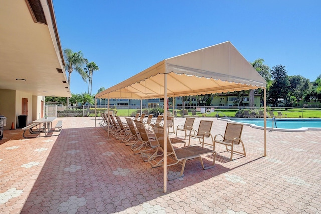 view of patio / terrace with a gazebo, a community pool, and fence