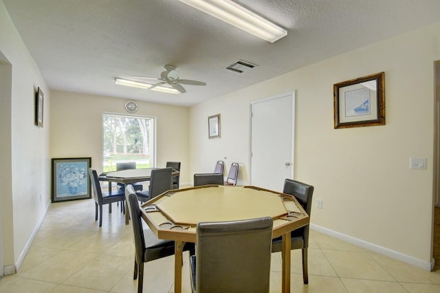 dining room featuring ceiling fan, a textured ceiling, visible vents, light tile patterned floors, and baseboards