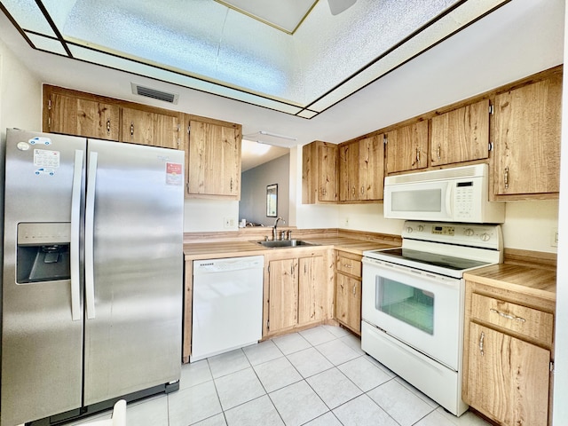 kitchen featuring visible vents, a sink, light tile patterned floors, light countertops, and white appliances