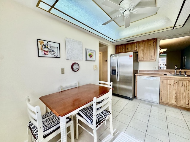 kitchen featuring a sink, dishwasher, a ceiling fan, light tile patterned floors, and stainless steel refrigerator with ice dispenser