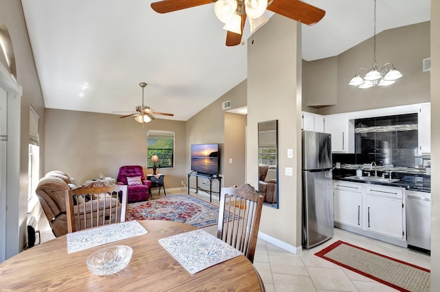 dining space featuring visible vents, ceiling fan with notable chandelier, light tile patterned floors, and high vaulted ceiling