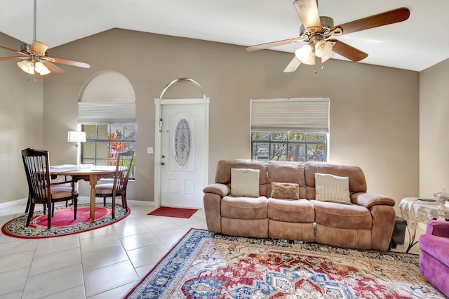 tiled living room featuring baseboards, ceiling fan, lofted ceiling, and a wealth of natural light