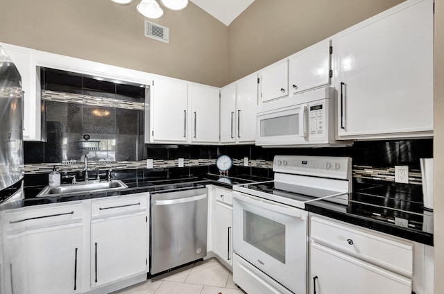 kitchen featuring a sink, backsplash, white appliances, and visible vents