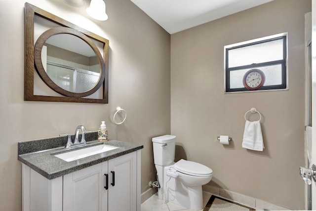 full bath with vanity, toilet, baseboards, walk in shower, and tile patterned floors