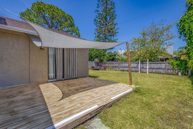 wooden deck with a fenced backyard and a yard