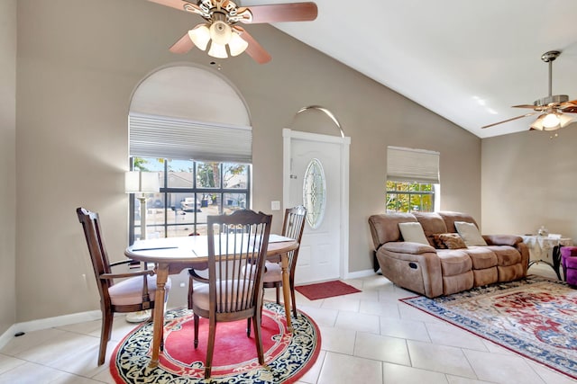 dining room featuring a ceiling fan, baseboards, light tile patterned flooring, and lofted ceiling