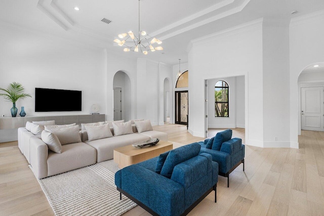 6581 Grande Orchid Way, Delray Beach, FL 33446 - living room with arched walkways, a raised ceiling, a chandelier, recessed lighting, and light wood-type flooring