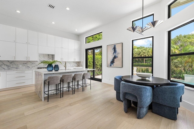6581 Grande Orchid Way, Delray Beach, FL 33446 - dining area with healthy amount of natural light, recessed lighting, light wood-style flooring, a chandelier, and a towering ceiling