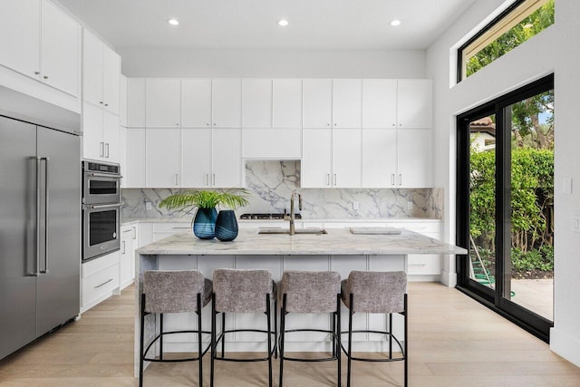 6581 Grande Orchid Way, Delray Beach, FL 33446 - kitchen featuring stainless steel appliances, light wood-type flooring, light stone counters, decorative backsplash, and recessed lighting