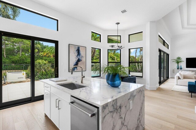6581 Grande Orchid Way, Delray Beach, FL 33446 - kitchen featuring dishwasher, light wood-type flooring, pendant lighting, white cabinetry, and light stone counters