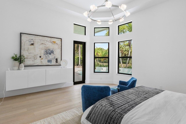 6581 Grande Orchid Way, Delray Beach, FL 33446 - bedroom with a chandelier, light wood-style floors, access to exterior, and a high ceiling