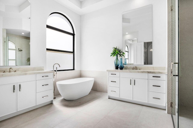 6581 Grande Orchid Way, Delray Beach, FL 33446 - bathroom with two vanities, a shower stall, a soaking tub, tile walls, and tile patterned flooring