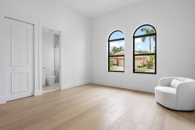 sitting room with light wood-type flooring and baseboards