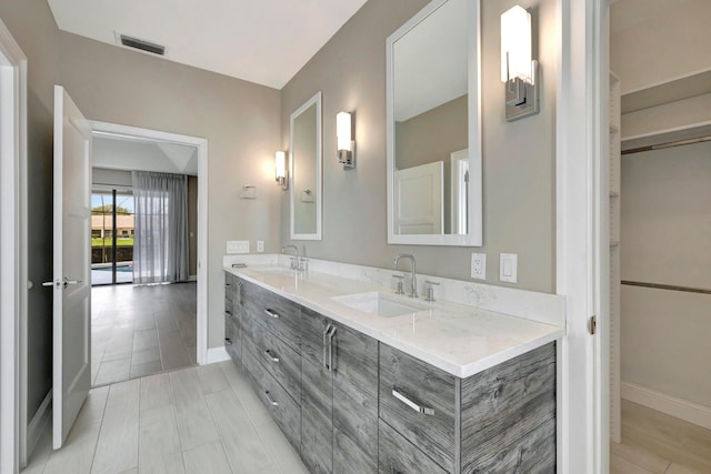 full bathroom featuring visible vents, a sink, baseboards, and double vanity