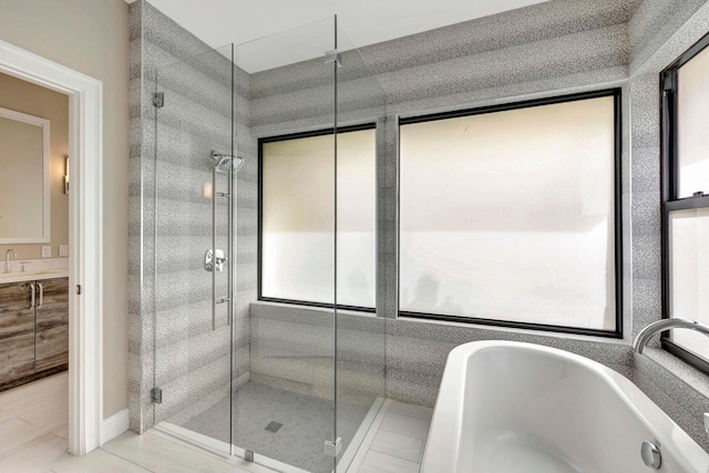 full bath featuring vanity, a freestanding bath, and a stall shower
