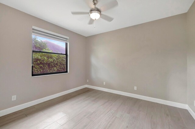 empty room with baseboards, ceiling fan, and wood finished floors