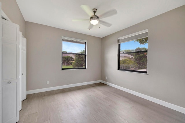 unfurnished bedroom with baseboards, multiple windows, light wood-type flooring, and ceiling fan