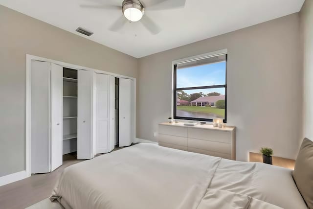 bedroom with visible vents, multiple closets, ceiling fan, and baseboards