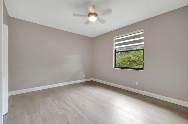 empty room with baseboards, ceiling fan, and light wood-type flooring