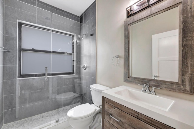 bathroom with vanity, a shower stall, and toilet