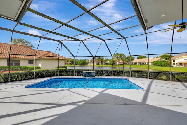 outdoor pool with glass enclosure, a patio, a water view, and a residential view