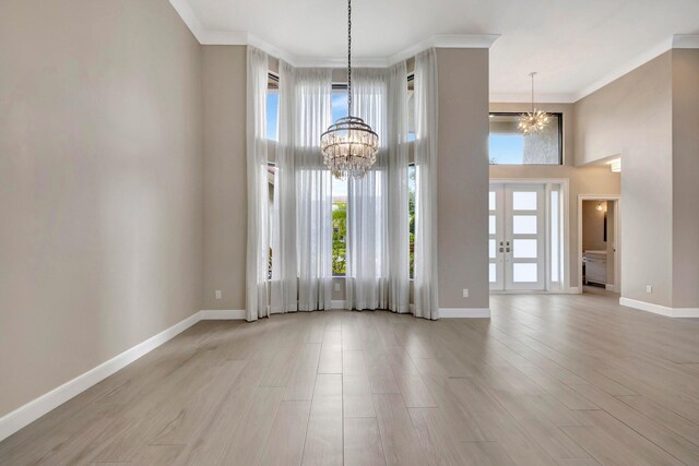 interior space featuring a high ceiling, a notable chandelier, and ornamental molding
